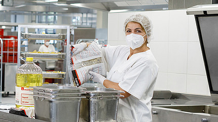 Mitarbeiterin des Küchenteams in der Großküche